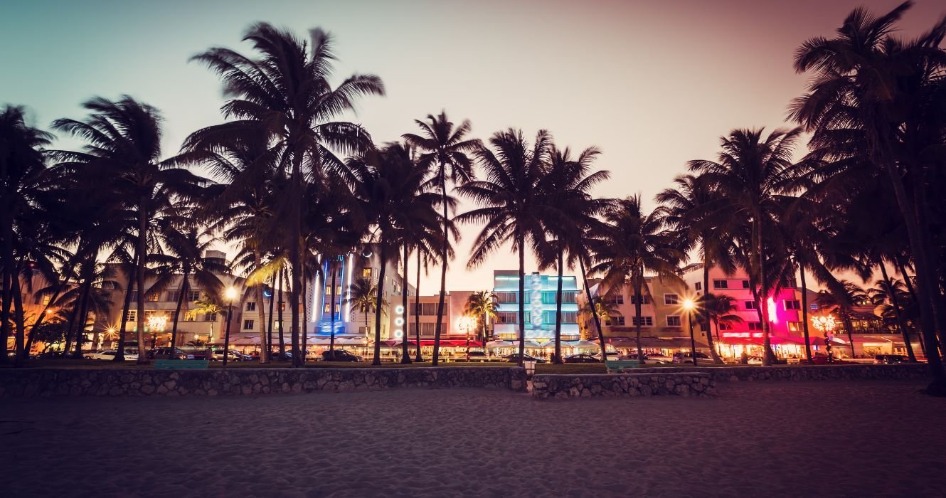 uma rua em frente à praia em miami à noite