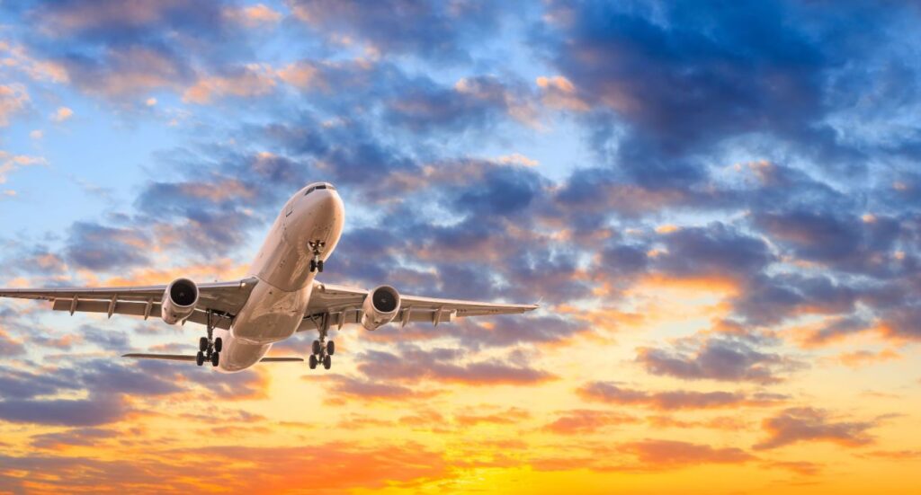 Commercial airplane flying in beautiful sky at sunset